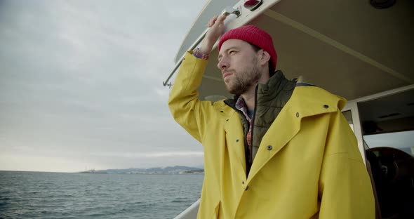 Sailor on a Boat in the Open Ocean Looks at the Horizon and Smiles