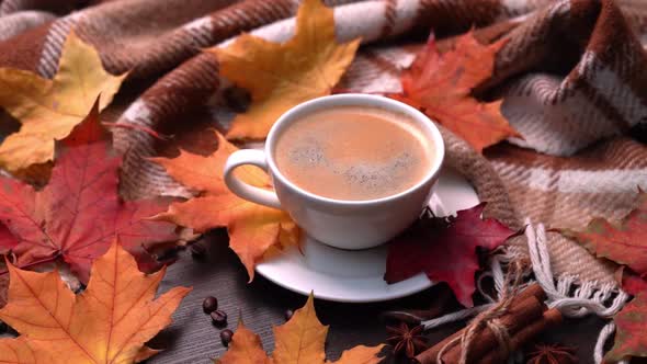 Autumn Fall Leaves Hot Cup of Coffee and Warm Plaid on a Wooden Table Background alt