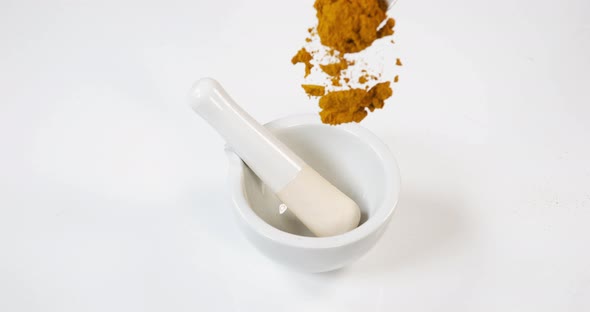 Curry Powder falling into a Mortar and Pestle against White Background, Slow motion 4K alt