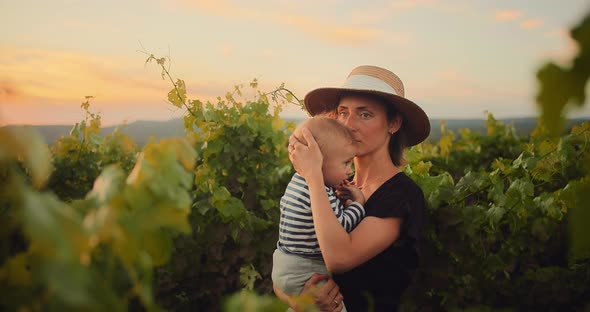 Happy Mother Enjoying Time with Her Cute Little Child in French Provence Vineyard During Summer alt