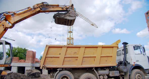 Excavator Loads Sand Into a Truck Body at a Construction Site, Industry alt