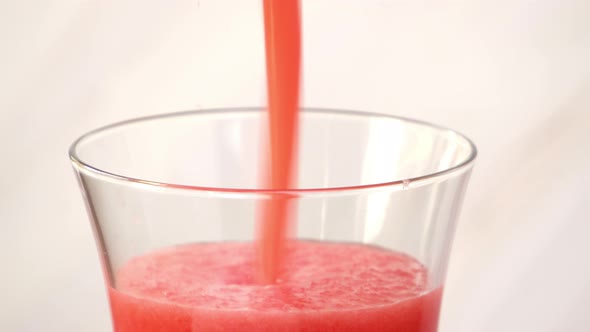 Watermelon fruit smoothie drink being poured in to the glass
