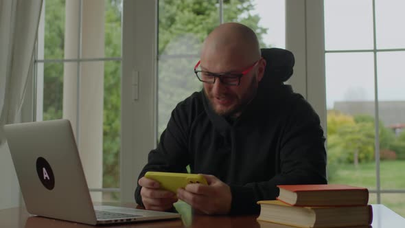 Exited 30s Man Playing Video Games on Mobile Phone and Losing the Game alt