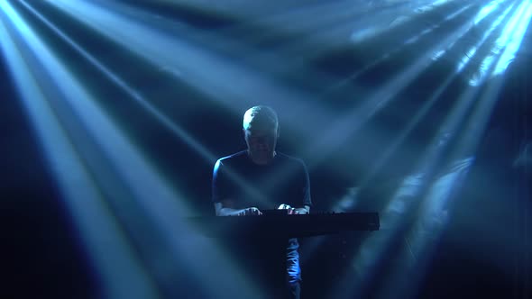 Musician Silhouette Playing on Synthesizer Piano Keyboard in Dark Studio with Neon Lighting. Dynamic alt