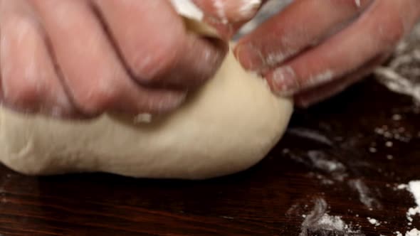 Closeup of Kneading Dough with Flour on the Table