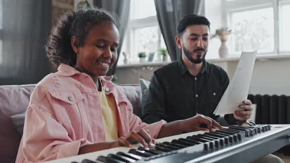 Happy Girl Playing on Synthesizer alt