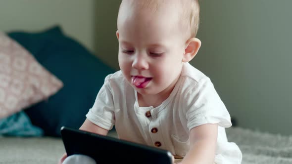 Curious Baby Boy Sitting on Bed and Exploring New Tablet