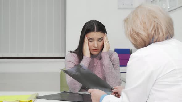 Young Woman with Terrible Headache Visiting Doctor alt