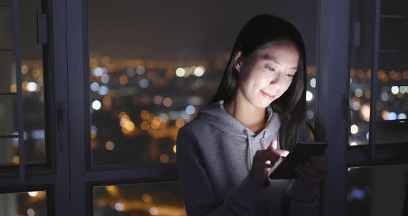 Woman look at mobile phone at home alt