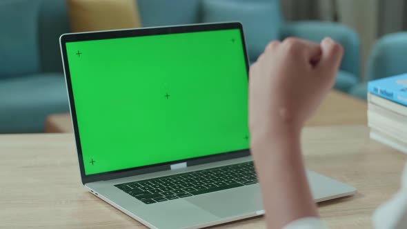 Close Up Of Asian Man Student Celebrating While Looking At Green Screen Computer At Home alt