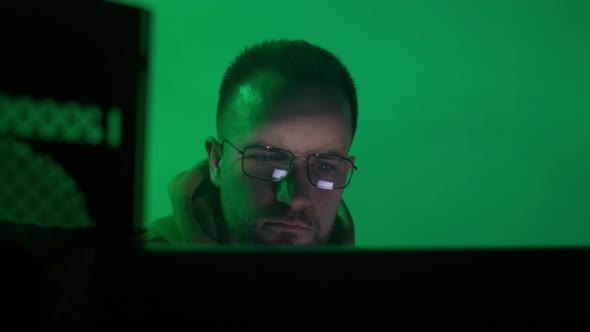A Caucasian Man in Glasses Works on the Computer Types Checks the Information Coding Studying alt