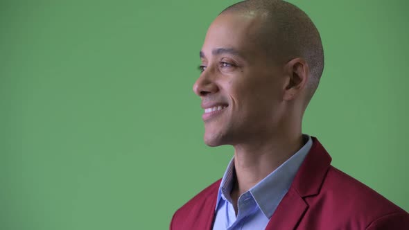 Closeup Profile View of Happy Bald Multi Ethnic Businessman Smiling alt