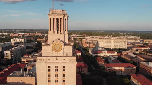 Slow aerial orbit of the UT tower with focus on the football stadium and eventually revealing downto alt