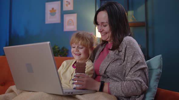 Mother and Small Child Daughter Kid Study at Laptop Watching Funny Movies Relaxing Lying on Sofa alt