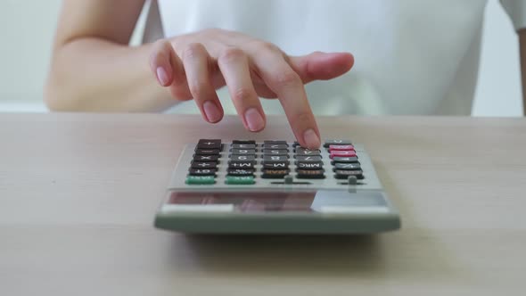 Hand press calculator to calculate income expenses and plans for spending money on home office. alt