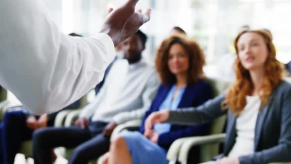 Businesspeople raising their hands during a meeting alt