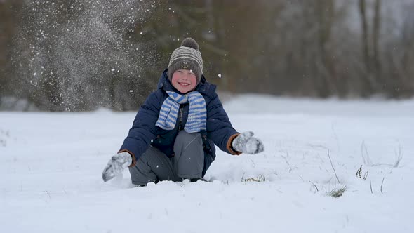 Happy child playing with snow.