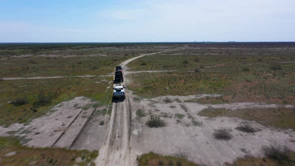 An Expedition of 3 Cars is Driving Through the Steppe Desert