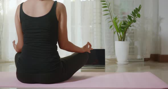 woman sitting legs crossed on mat coach internet video online workout training yoga alt