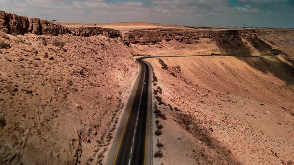 Car Driving on Road Through the Desert the Camera Flies Over the Land the Landscape in Israel