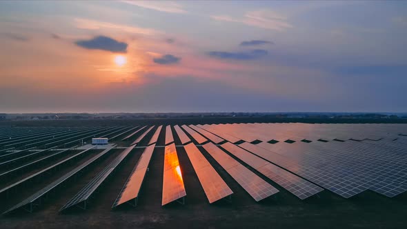 Timelapse Aerial Drone View Into Large Solar Panels at a Solar Farm at Early Spring Sunset alt
