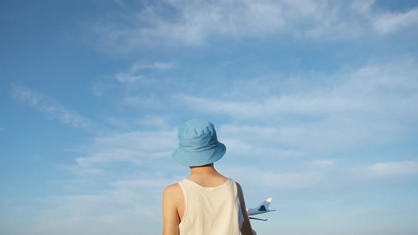 Boy in a Blue Hat Playing with Airplane on Sky Background, Boy Wants To Become a Pilot, Background