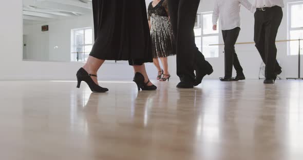 mixed race male dance teacher taking a ballroom dancing class at a dance studio alt