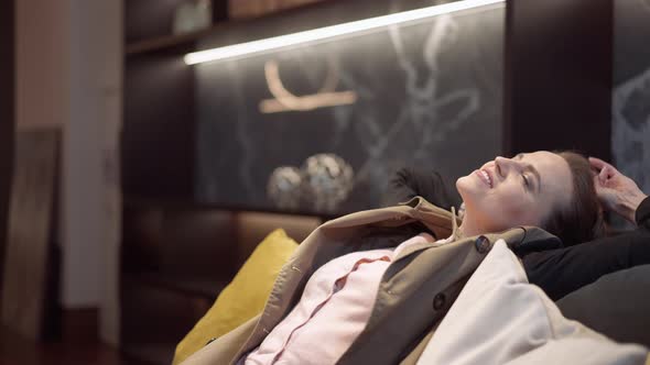 Relaxed Wealthy Caucasian Beautiful Woman Leaning on Soft Couch in Showroom Smiling alt