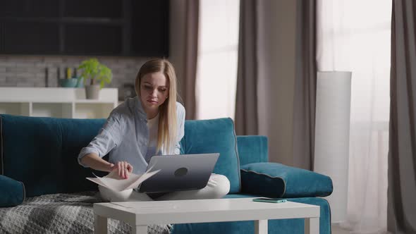 Excited Young Woman Winner Looks at Laptop Celebrates Online Success Sits on Sofa at Home alt