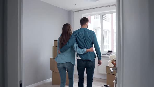  Couple in Love which Embracing and Approaching to the Big Window in Their New Flat alt