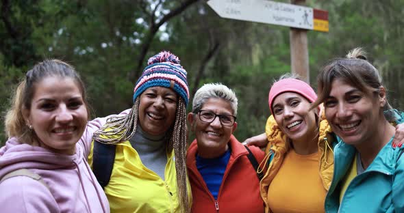 Multiracial women having fun during trekking day in to the wood - Escape to nature and travel alt
