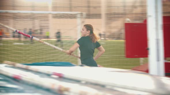 Young People on the Pole Vault Training on the Stadium - Young Men Talking and Young Woman Jumping alt