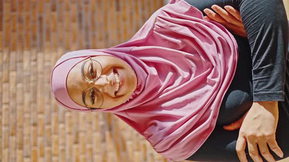 Indoor Vertical Video of Young Muslim Woman Wearing Pink Hijab and Glasses alt