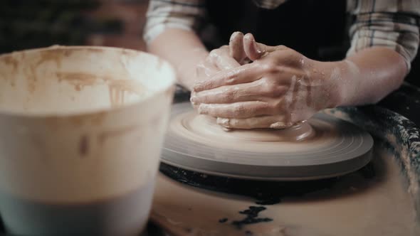 Man Potter Working on Potters Wheel Making Ceramic Pot From Clay in Pottery Workshop alt