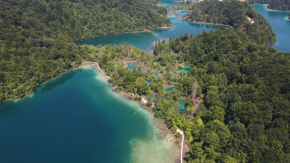 View of the Plitvice Lakes National Park with many green plants and blue lakes and waterfalls drone alt