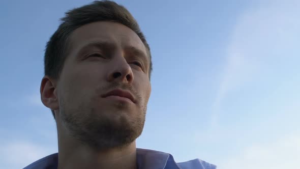 Handsome Man Contemplating About Future on Background of Bright Sky, Close-Up