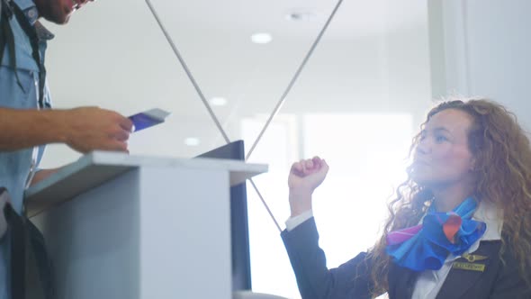 Caucasian Airline staff hand passport to young man traveler at check in counter in airport terminal alt