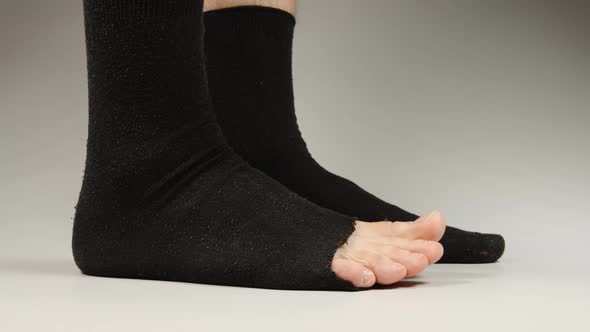 Side view of socks with a hole on the man's legs