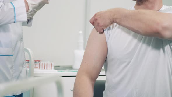 Male Patient is Getting His Arm Injected with a Vaccine alt