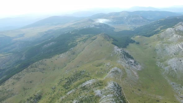 Aerial view of smoke rising above Dinara mountain tops alt