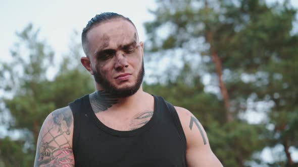 Man Sharpening Wooden Shavings with a Knife on Nature and Throwing Them Down alt
