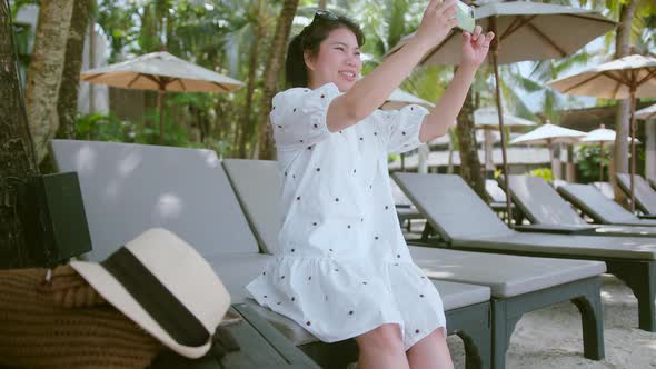 asian female traveller wear casual cloth dress enjoy vacation sunset moment hand use smartphone