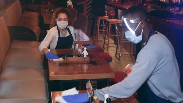A Waitress and a Waiter are Cleaning the Cafe During Pandemic alt