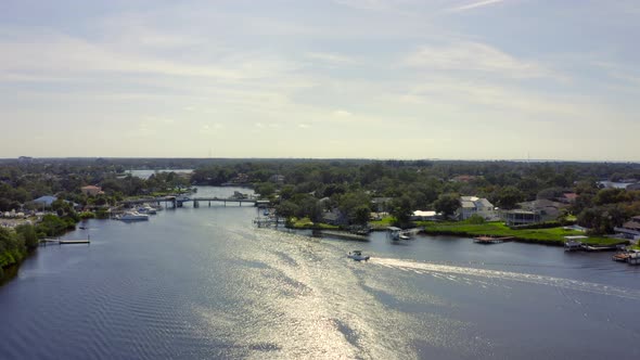 Slow Forward Aerial Pan of a Speed Boat on Bay by Waterfront Houses in Florida alt