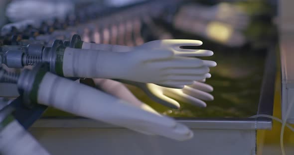 Closeup Treatment of Rubber Gloves with a Special Solution on the Conveyor alt