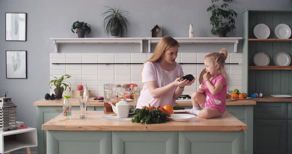 Beautiful Mother Cooking Dinner on Kitchen with Little Kid