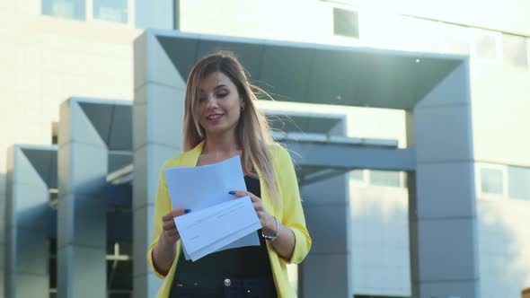 Businesswoman in Yellow Jacket Throws Paper Documents alt
