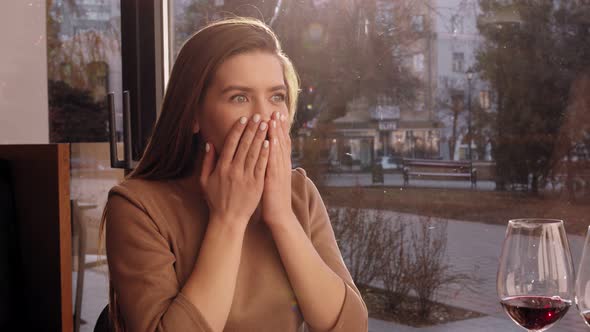 Close Up Shot of Young Surprised Woman Looking at Table During Date in Cafe Slow Motion alt