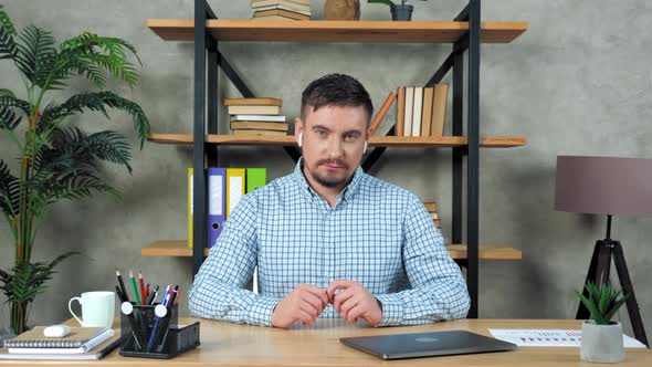 Businessman sitting on chair looks camera listens online video call chat webcam alt