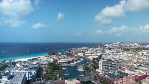 Air drone moves over Bridgetown, Barbados on sunny day. On the horizon the sea turns into the sky alt